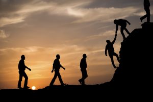 Silhouette of helping hand between two climber